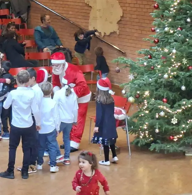 Ein Weihnachtsmann verteilt Süßigkeit an Kinder.