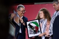 Unser Foto (© Eurokinissi) ist am Samstag während der Veranstaltung der KKE in Athen entstanden. Zu sehen ist die palästinensische Aktivistin Ahed Tamimi (m.) und der Generalsekretär der KKE Dimitris Koutsoumbas (l.).