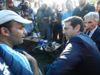 Unser Archivfoto (© Eurokinissi) entstand im Oktober 2015 während eines offiziellen Besuchs des griechischen Ministerpräsidenten Alexis Tsipras (m.) und des damaligen Bundeskanzlers der Republik Österreich Werner Faymann (r.) in einem Flüchtlingslager auf der Insel Lesbos.