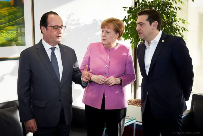 Unser Archiv-Foto (© Eurokinissi) entstand im Februar 2016. Rechts im Bild: Ministerpräsident Alexis Tsipras, Bildmitte: die deutsche Bundeskanzlerin Angela Merkel, links: Frankreichs damaliger Präsident François Hollande.