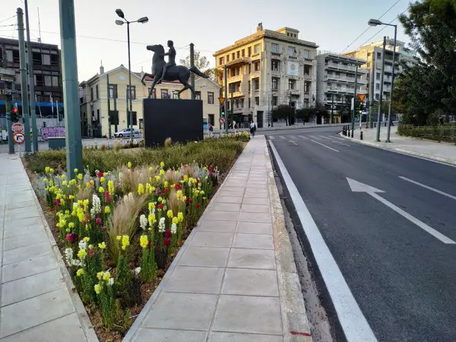 Unser Foto (© GZak) zeigt den frischen Asphalt und die neuen Blumen am Alexander-Denkmal in Athen