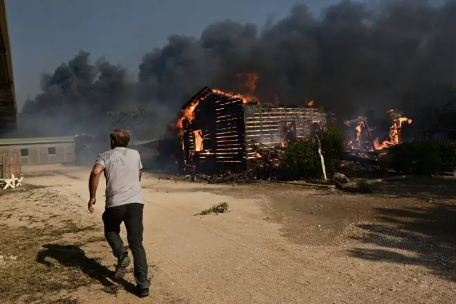  Erste Gebäude werden Opfer der Flammen in Kouvaras. (© Eurokinissi)