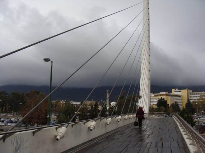 Das Archivfoto (© Griechenland Zeitung / Jan Hübel) zeigt die Kalatrava-Fußgänger-Brücke bei stürmischem Wetter in Athen.