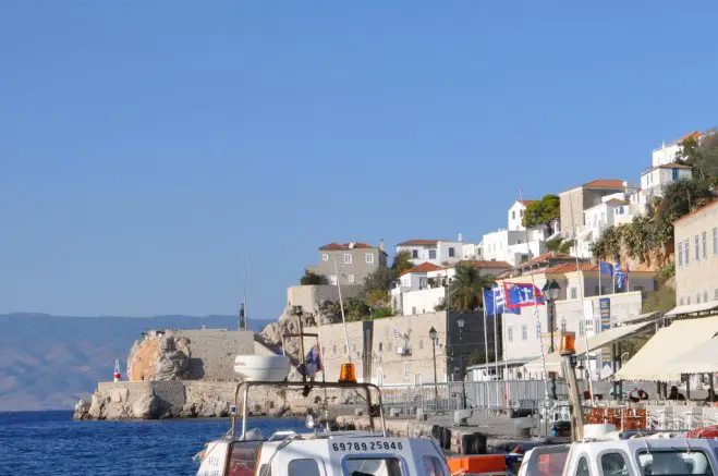 Das Foto (© GZ / Elisa Hübel) entstand im Hafen der Insel Hydra. Auf der rechten Seite ist das Museum mit den Flaggen und Bannern zu erkennen.