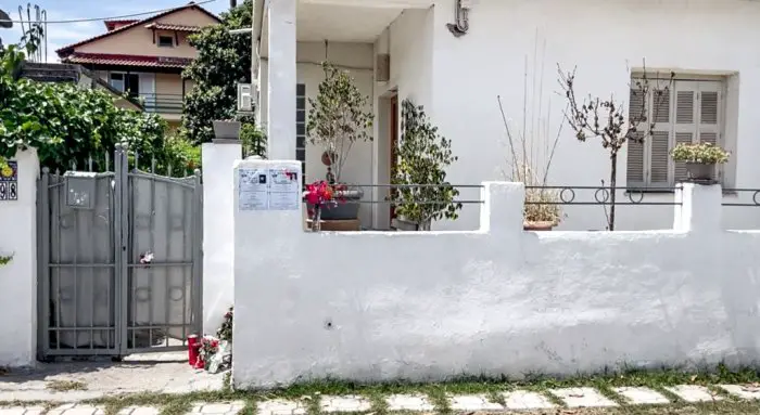 Unser Foto (© Eurokinissi) entstand vor dem Haus der Ermordeten in Longos bei Aegio.
