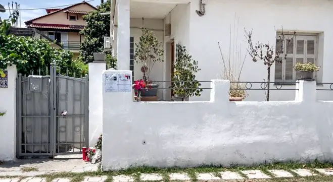 Unser Foto (© Eurokinissi) entstand vor dem Haus der Ermordeten in Longos bei Aegio.