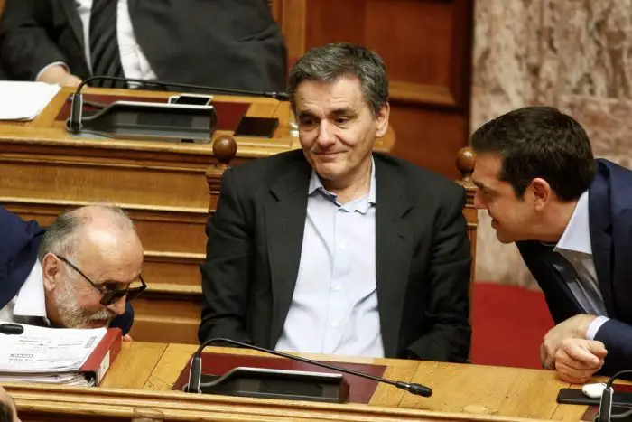 Unser Foto (© Eurokinissi) entstand am Donnerstag während der Debatte im Parlament. Rechts im Bild: Premier Alexis Tsipras, in der Mitte: Finanzminister Evklidis Tsakalotos und links der Minister für Handelsschifffahrt und Inselpolitik und Panajotis Kouroublis, für den eine Wahlurne aufgestellt wurde.