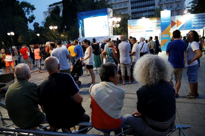 Unser Archivfoto (© Eurokinissi) entstand während der Parlamentswahlen am 20. September 2015 am Syntagmaplatz vor dem Parlament, wo interessierte Bürger die Wahlergebnisse zur Kenntnis nahmen. Damals wurde das Linksbündnis SYRIZA erneut als stärkste politische Kraft gewählt.