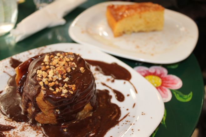Das Foto (© Madlien Wienberg) zeigt eine Art Baklava-Nest mit Schokoladensauce und den traditionellen griechischen Grießkuchen Ravani. 