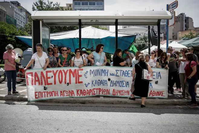 Unser Foto (© Eurokinissi) entstand bereits am vorigen Dienstag (22.5.) während eines Streiks des Reinigungspersonals der öffentlichen Schulen vor dem Innenministerium in Athen.