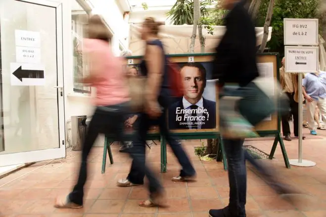 Unser Foto (© Eurokinissi) entstand am Sonntag, dem Tag der Wahl, vor dem Französischen Institut in Athen. Bürger aus Frankreich, die sich in Griechenland aufhalten, machten hier von ihrem Wahlrecht Gebrauch.