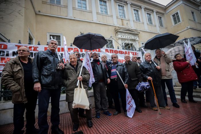 Archivfoto (© Eurokinissi). Im Regen: Demonstration von Rentnern vor dem Arsakion-Megaron in der Panepistimiou-Straße in Athen. Es folgte ein Protestmarsch in Richtung Parlament.