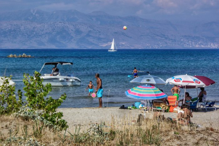 Sommer, Sonne, Ferienstrand in Griechenland. Aber Covid-19 schläft nicht … Unser Foto (© Eurokinissi) entstand im nördlichen Teil der Insel Kerkyra (Korfu).