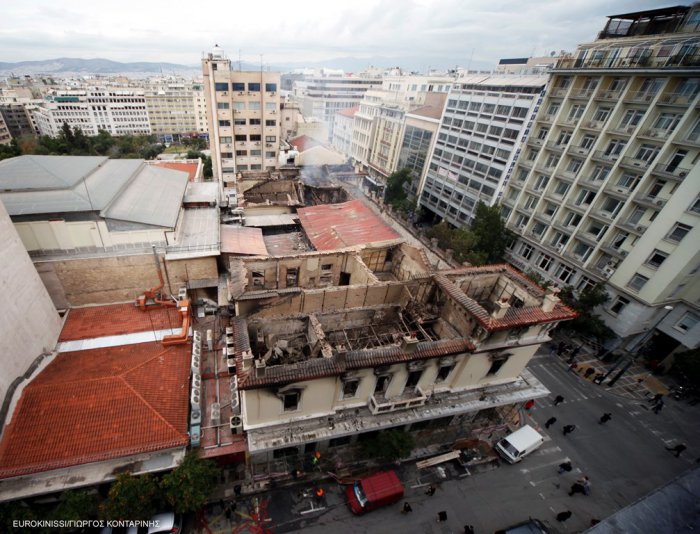 Foto (© Eurokinissi): Das ausgebrannte Gebäude Stadiou, Ecke Christou Lada. Links erkennt man das Dach des Kinos „Attikon“.
