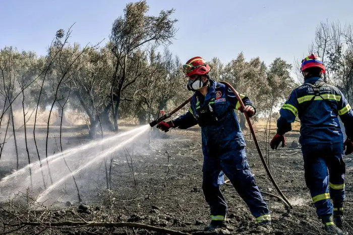 Die Aufnahme zeigt Feuerwehrleute bei Löscharbeiten. Sie entstand nahe des antiken Nemea, in der Nähe von Korinth auf der Peloponnes (© Eurokinissi).