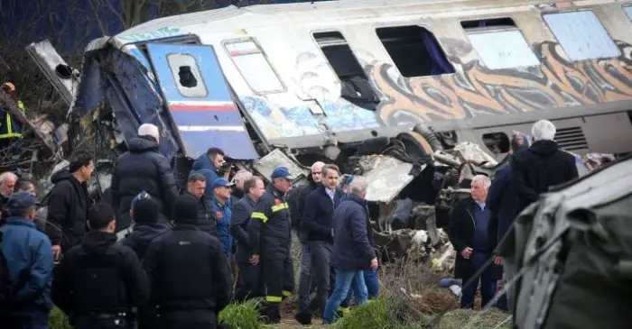 Unser Foto (© Eurokinissi) zeigt eine Regierungsdelegation am Unfallort, an der sich Premierminister Kyriakos Mitsotakis und der ehemalige Transportminister Kostas Achilleas Karamanlis beteiligt haben.