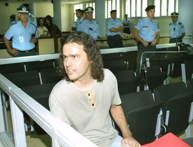 Unser Archivfoto (© Eurokinissi) ist 2003 entstanden. Es zeigt Savvas Xiros im Rahmen seine Aussage vor Gericht.