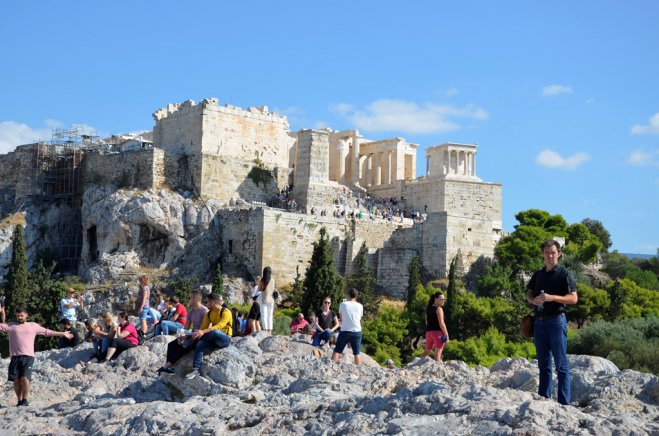 Unser Archivfoto (© Griechenland Zeitung / Jan Hübel) zeigt Touristen unterhalb der Athener Akropolis.