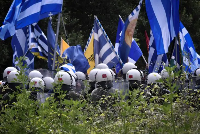 Unser Foto (© Eurokinissi) entstand am Sonntag, 17.6., angesichts der Vertragsunterzeichnung über die Lösung der Namensfrage in der Nähe der Prespes-Seen auf der griechischen Seite. Ähnliche Szenen spielten sich auch im Nachbarland FYROM ab.