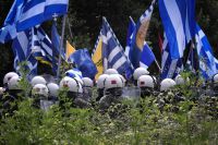 Unser Foto (© Eurokinissi) entstand am Sonntag, 17.6., angesichts der Vertragsunterzeichnung über die Lösung der Namensfrage in der Nähe der Prespes-Seen auf der griechischen Seite. Ähnliche Szenen spielten sich auch im Nachbarland FYROM ab.