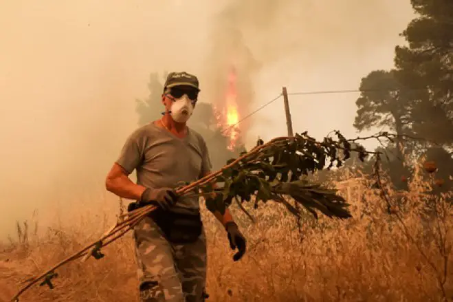 Mit dem Mut der Verzweiflung kämpfen Berufsfeuerwehrleute und Freiwillige gegen die Brände (unser Foto, © Eurokinissi, wurde auf Euböa aufgenommen).