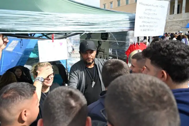 Unser Foto (© Eurokinissi) zeigt Panos Routsis im Gespräch mit Passanten, die ihm gegenüber Solidarität unter Beweis stellen.