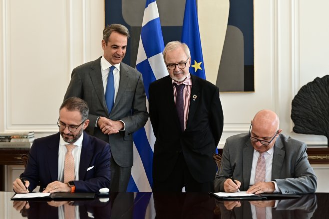 Unser Foto (© Eurokinissi) zeigt Premierminister Kyriakos Mitsotakis (stehend, l.) und den Präsidenten der Europäischen Investitionsbank, Dr. Werner Hoyer (stehend, r.). 