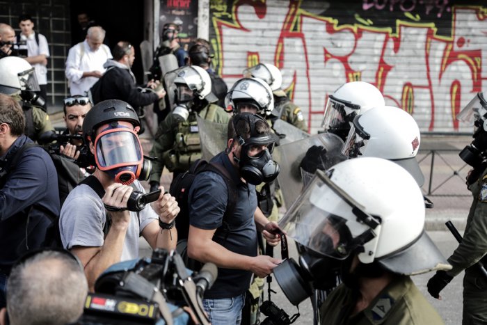 Foto (© Eurokinissi): Die Polizei drängt Journalisten ab: Kritische Berichterstattung hat es in Griechenland nicht immer leicht.
