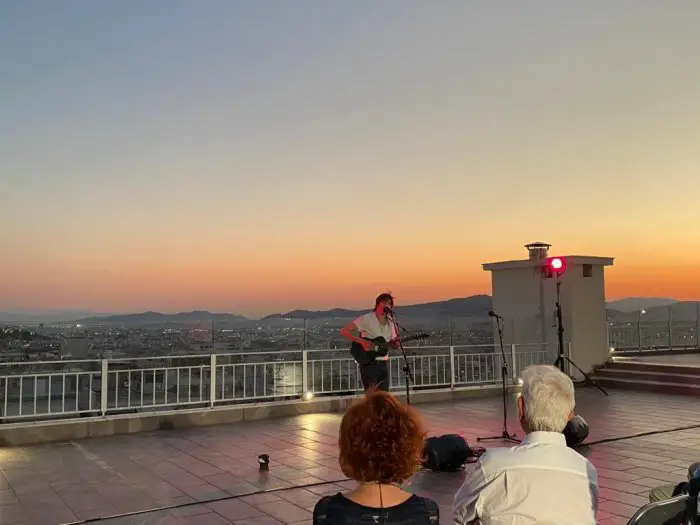 Der Musiker Marc Aymon, bei seinem Auftritt vor der Kulisse eines Athener Sonnenuntergangs (© GZtl)