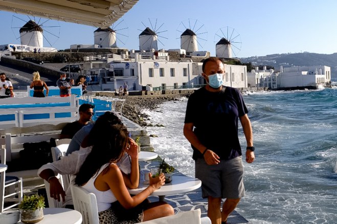 Unser Foto (© Eurokinissi) entstand auf der Insel Mykonos, wo in allen öffentlichen Räumen - drinnen und draußen - Maskenpflicht herrscht.