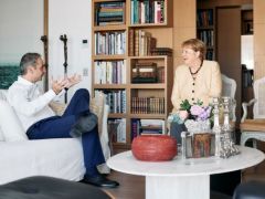 Unser Foto (© Eurokinissi) entstand am Donnerstag (3.7.) während eines Treffens zwischen Premierminister Kyriakos Mitsotakis (l.) und der ehemaligen deutschen Bundeskanzlerin Angela Merkel.